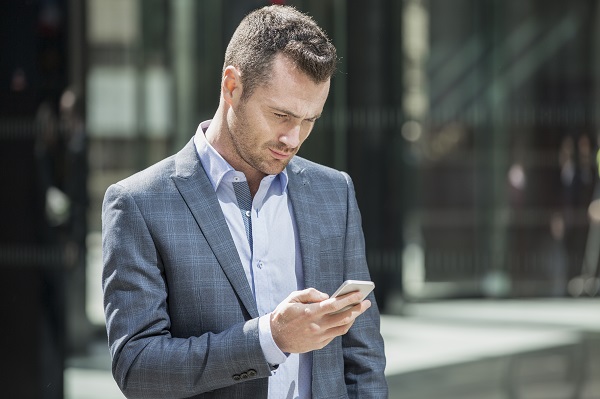 Leesvoeritem zakenman kijkt op mobiele telefoon