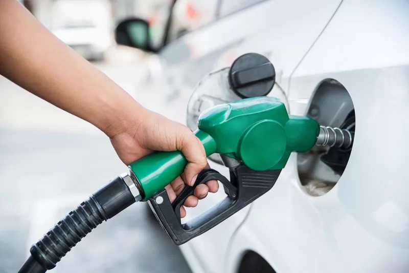Hand met een benzine pomp die aan het tanken is